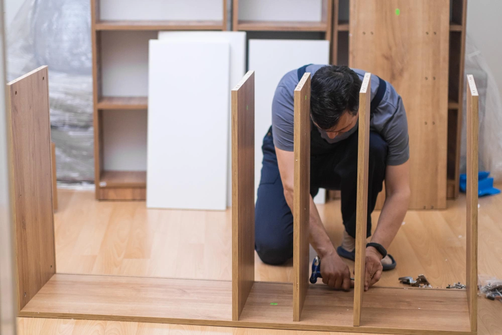Closet technician assembling wood panels for a built-in closet system in Los Angeles 