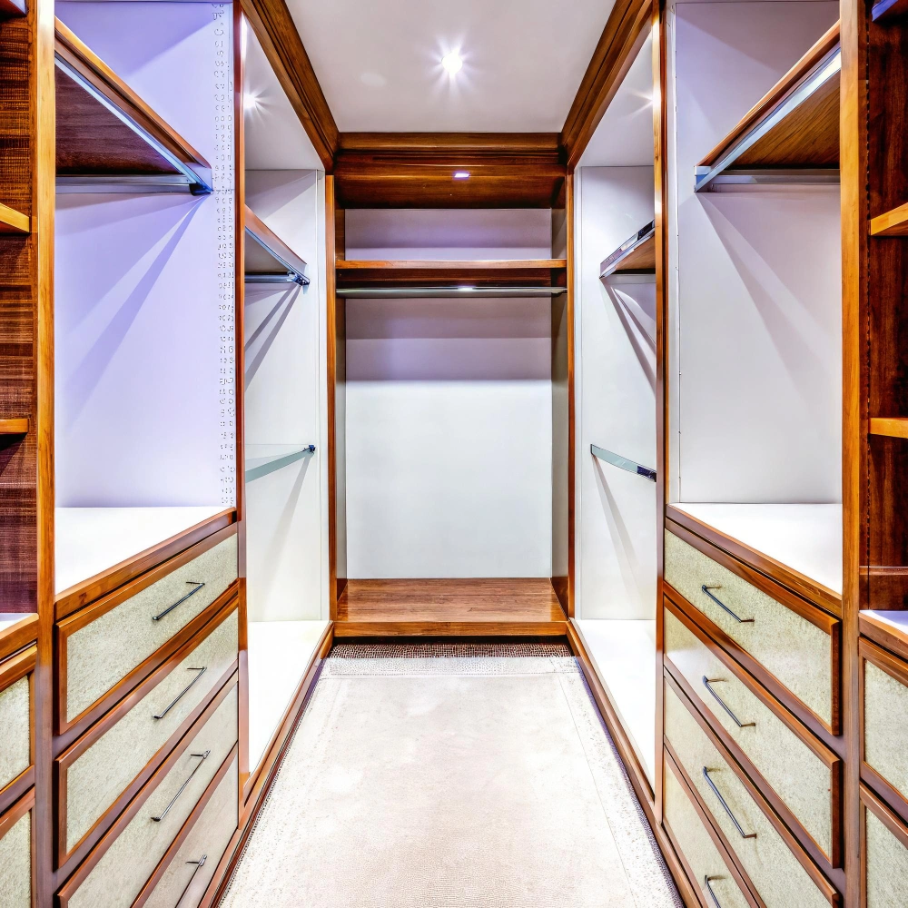 Modern walk-in closet with wood finish, drawers, shelves, and lighting in a Los Angeles home