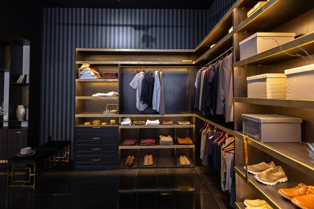 Brightly lit walk-in closet with open shelving and hardwood flooring by Los Angeles Closet
