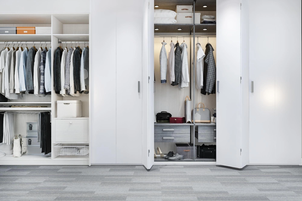 Custom reach-in closet with built-in drawers, overhead storage, and lighting by Los Angeles Closet